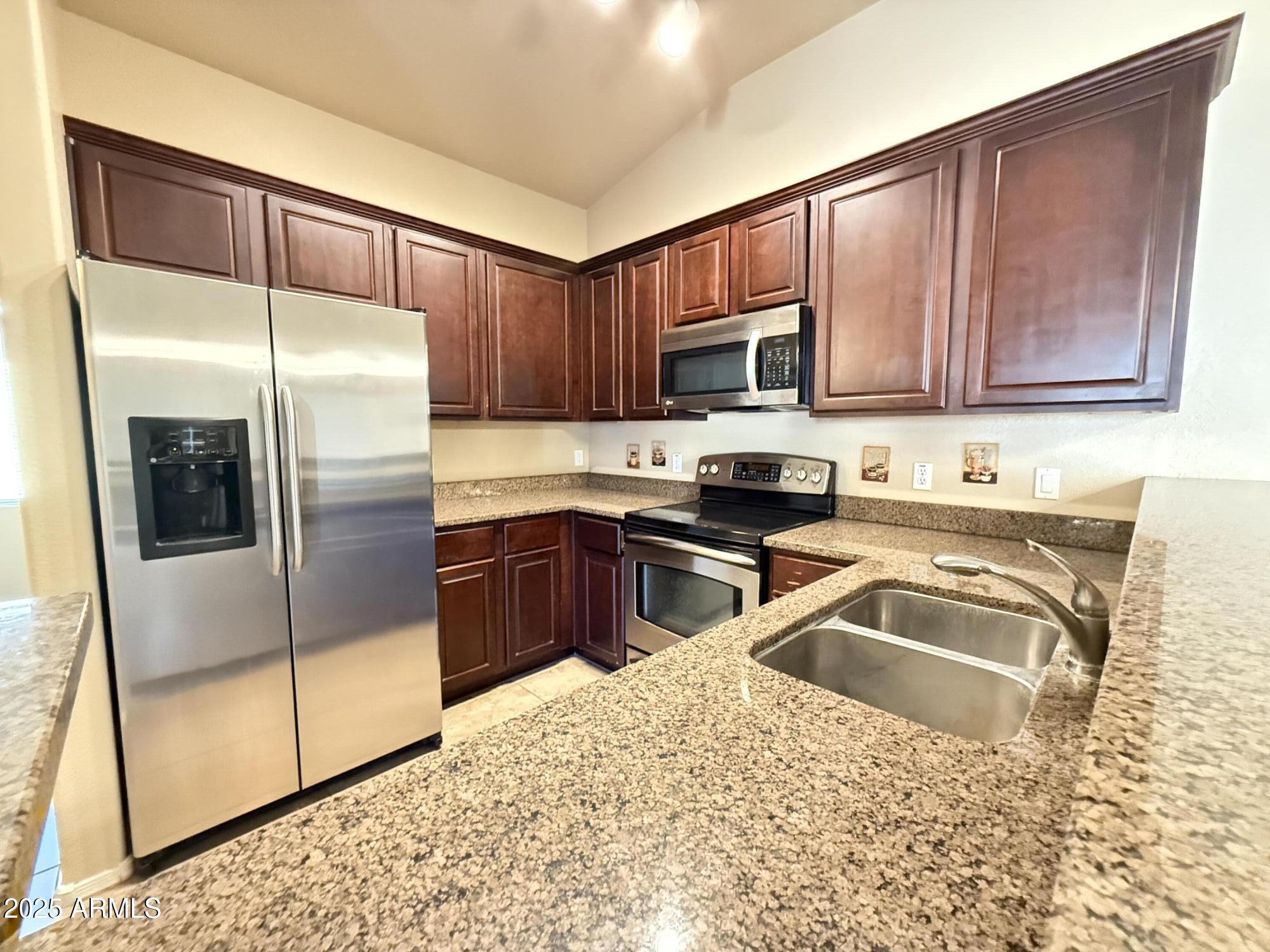 17150 North 23rd Street, Unit 243 Phoenix, AZ 85022 - Photo 8 of 36 a kitchen with granite countertop a refrigerator sink and microwave