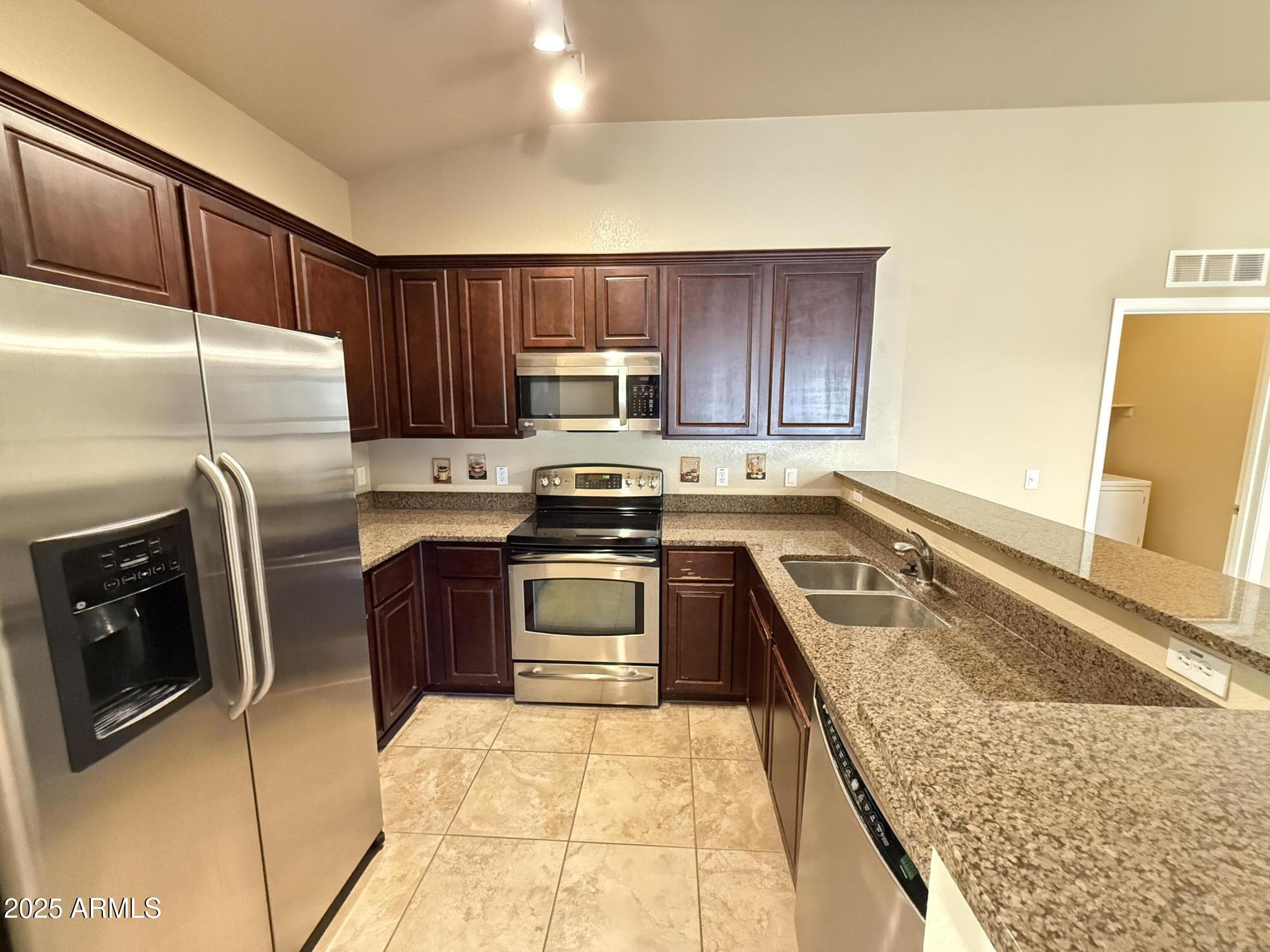 17150 North 23rd Street, Unit 243 Phoenix, AZ 85022 - Photo 9 of 36 a kitchen with stainless steel appliances granite countertop a refrigerator sink and stove