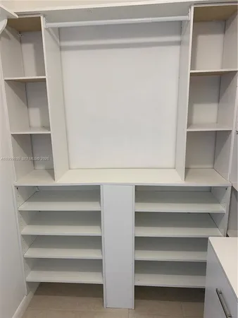 a view of walk in closet with empty racks