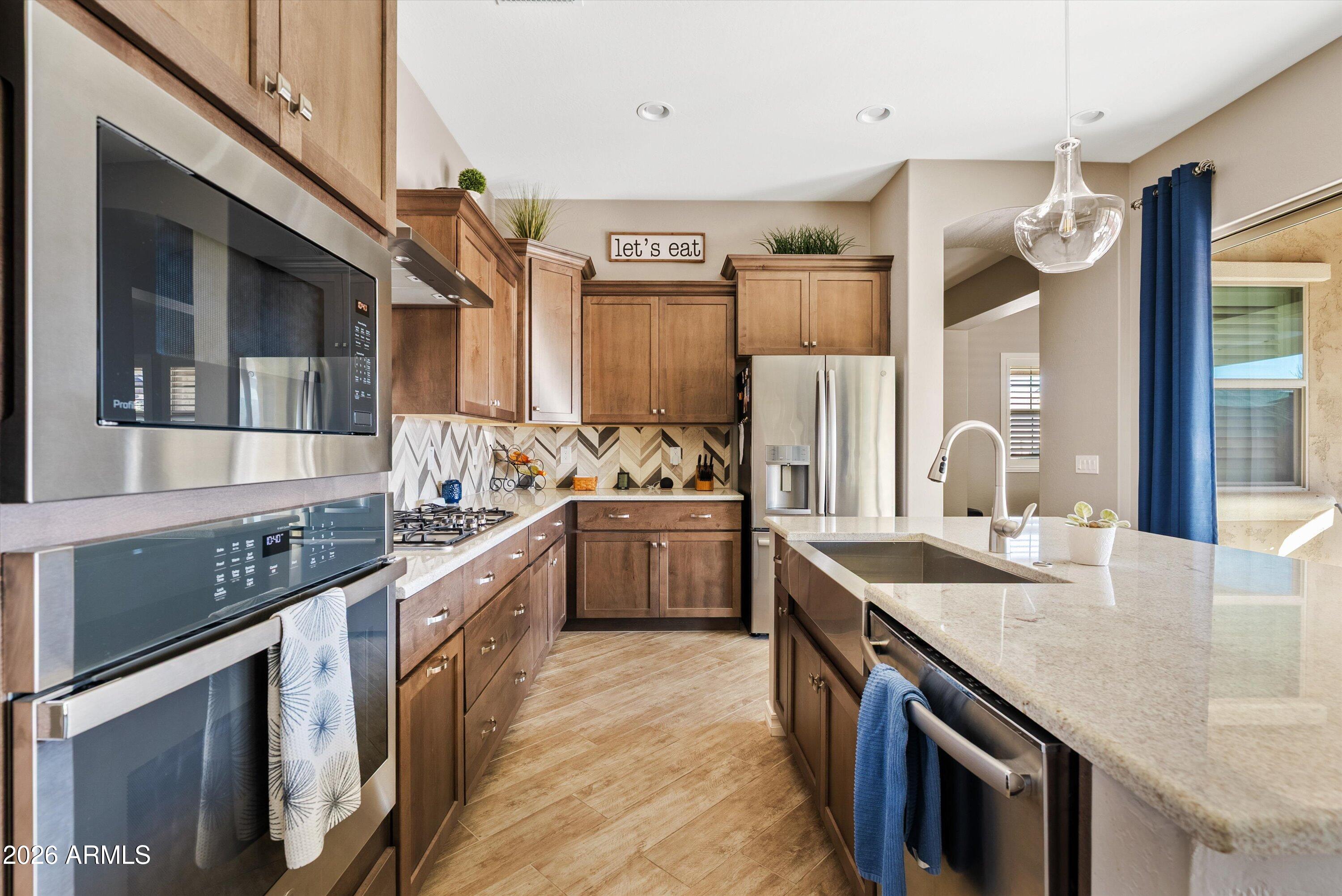 4405 East Dwayne Street Gilbert, AZ 85295 - Photo 15 of 38 a kitchen with stainless steel appliances granite countertop a sink a stove and a refrigerator