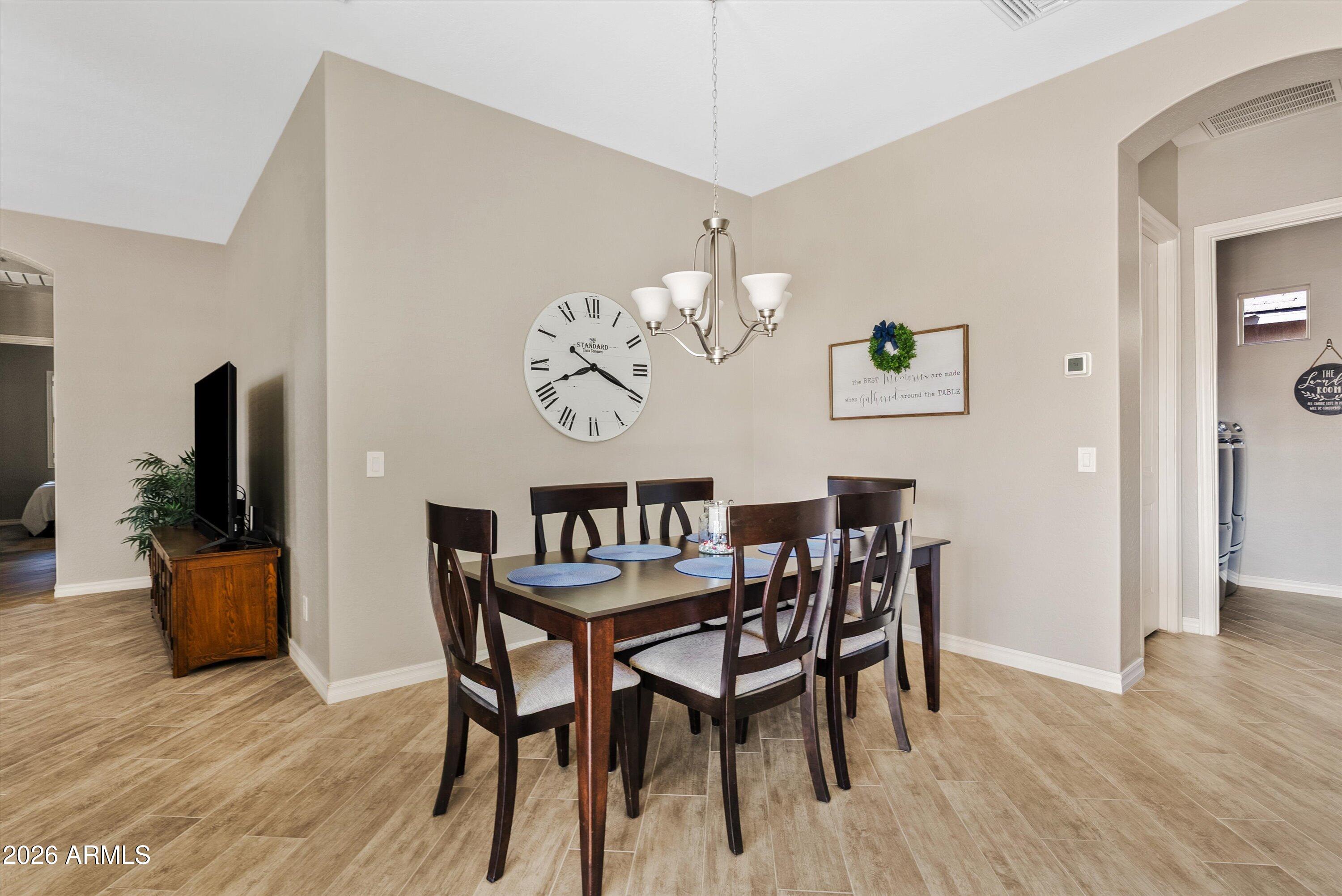 4405 East Dwayne Street Gilbert, AZ 85295 - Photo 18 of 38 a view of a dining room with furniture wooden floor and a chandelier