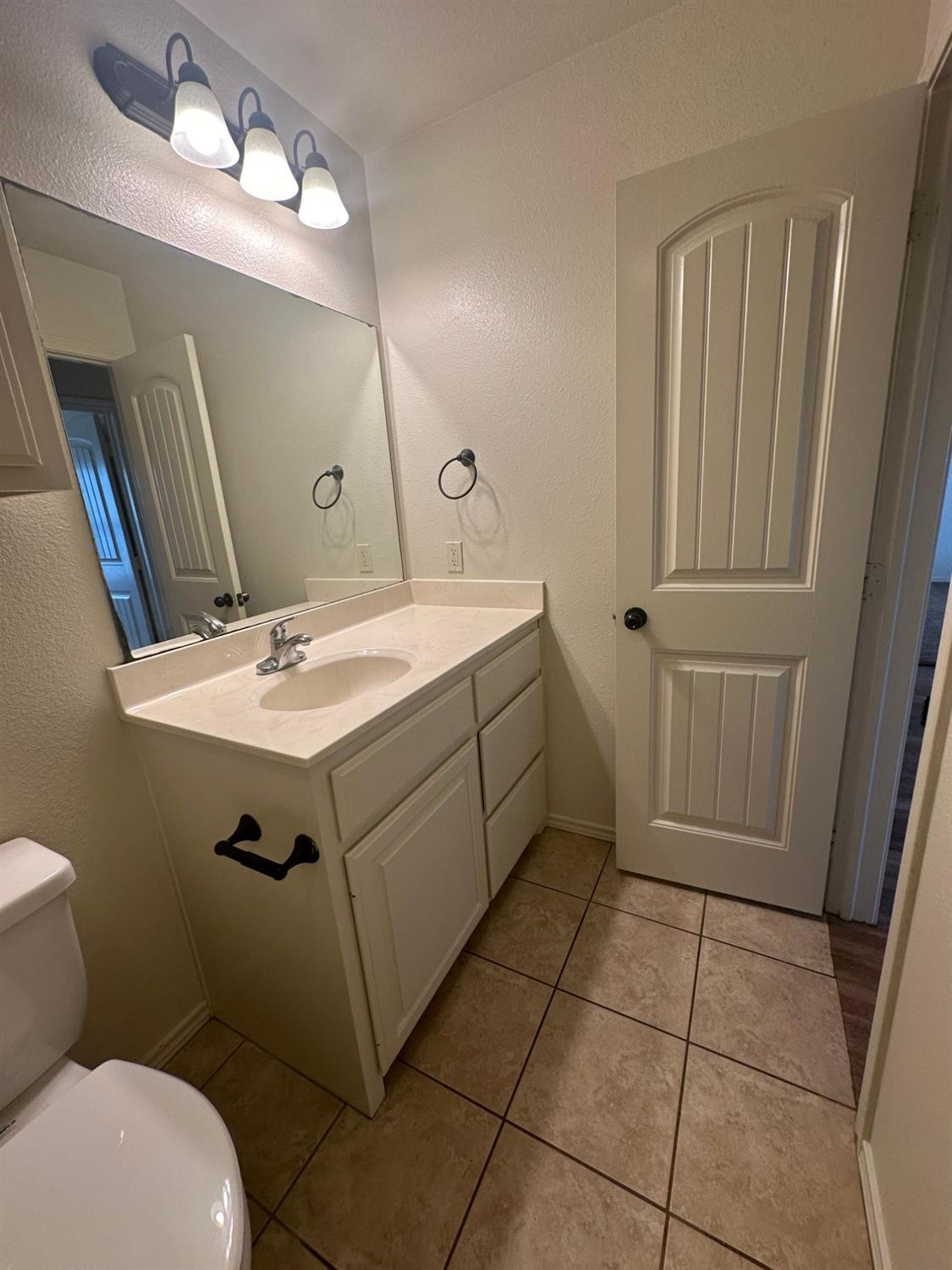 6133 72nd Place, Unit B Lubbock, TX 79424 - Photo 15 of 20 a bathroom with a sink a toilet and mirror