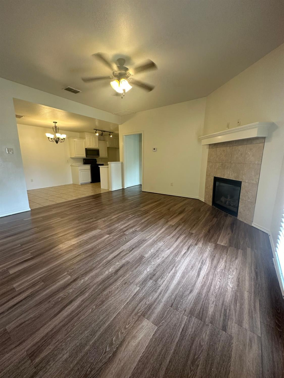 6133 72nd Place, Unit B Lubbock, TX 79424 - Photo 4 of 20 wooden floor in an empty room with a fireplace