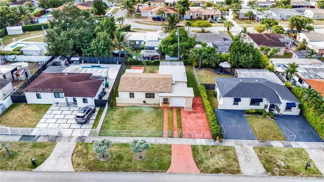 an aerial view of residential houses with yard