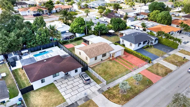 an aerial view of a house with swimming pool and outdoor seating