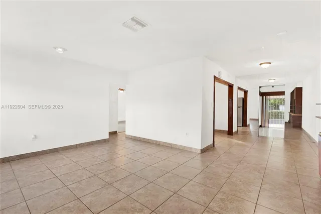 an empty room with entrance and hall with wooden floor