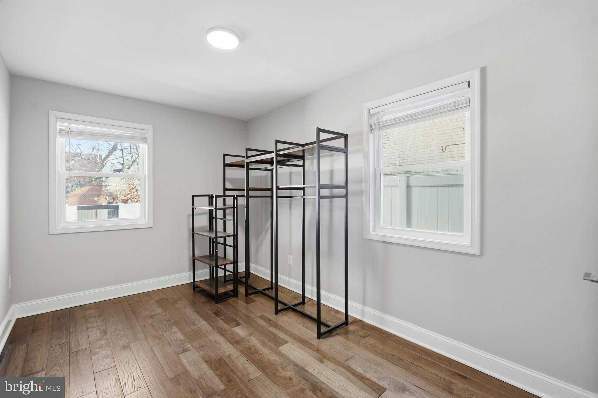 422 Burbank Street Southeast Washington, DC 20019 - Photo 11 of 23 an empty room with wooden floor and windows