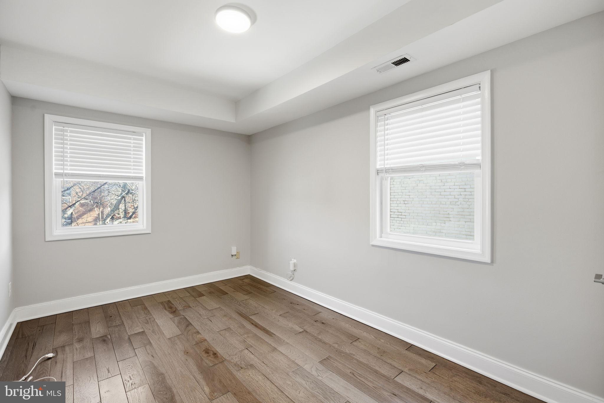422 Burbank Street Southeast Washington, DC 20019 - Photo 13 of 23 an empty room with wooden floor and windows