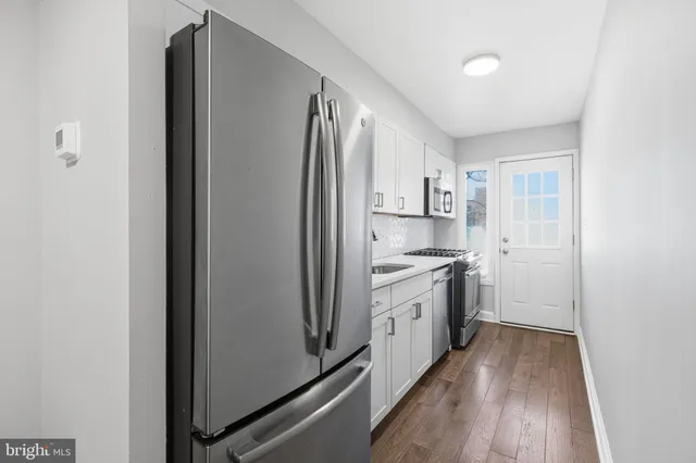 a kitchen with white cabinets and stainless steel appliances
