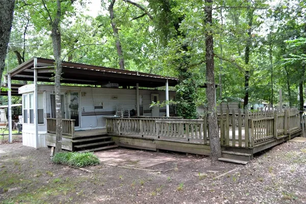 a view of house with a small yard and a large tree