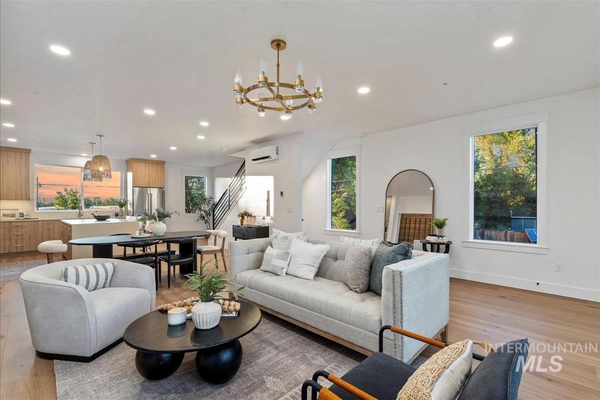 3219 West Moore Street Boise, ID 83702 - Photo 9 of 34 Living room featuring light wood finished floors, a chandelier, recessed lighting, and healthy amount of natural light