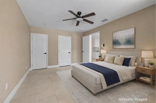 a spacious bedroom with a bed and a ceiling fan