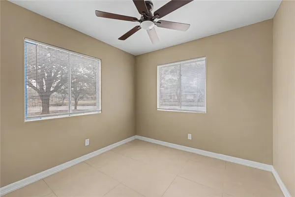 an empty room with a window and a ceiling fan