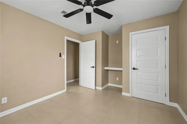 an empty room with closet and ceiling fan
