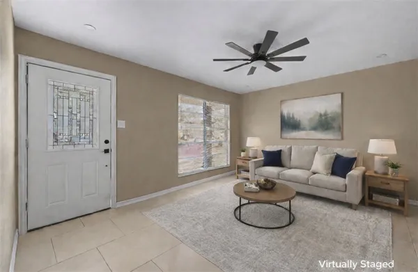 a living room with furniture a window and a ceiling fan