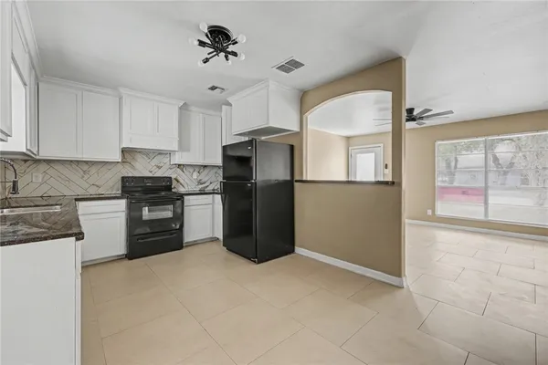 a kitchen with granite countertop a refrigerator and a stove