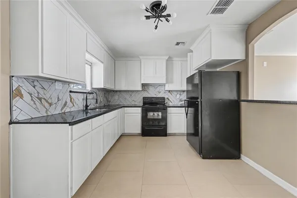 a kitchen with granite countertop a refrigerator oven a sink and dishwasher