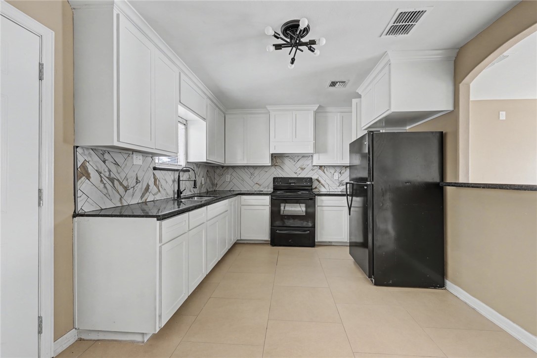 302 Palm Tree Drive Mathis, TX 78368 - Photo 10 of 28 a kitchen with granite countertop a refrigerator and a sink