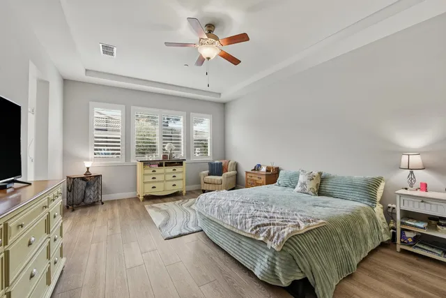 a spacious bedroom with a bed a table and a chandelier