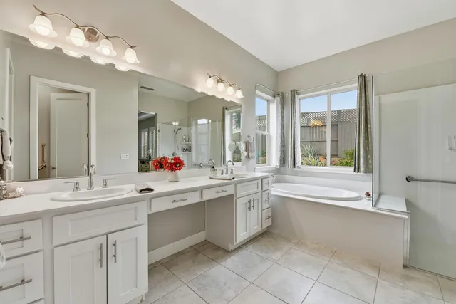 a large bathroom with a large tub sink vanity and mirror