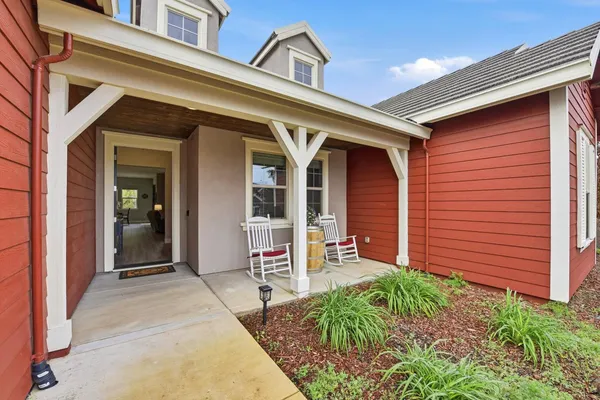 front view of a house with a large window and potted plants