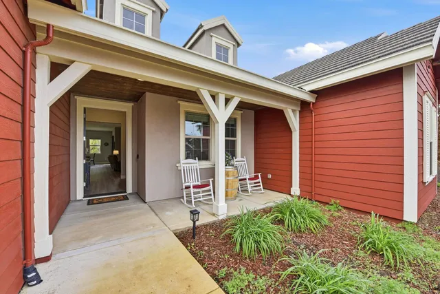 front view of a house with a large window and potted plants