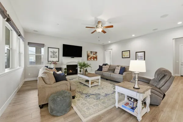 a living room with furniture a fireplace and a flat screen tv