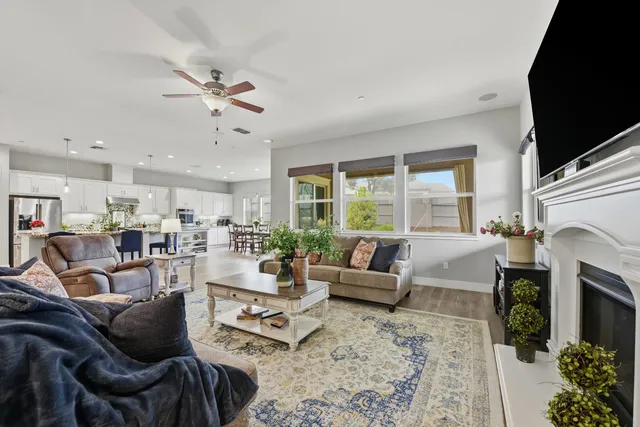 a living room with furniture fireplace and a large window