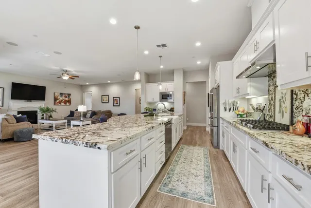 a large kitchen with kitchen island a sink appliances and cabinets