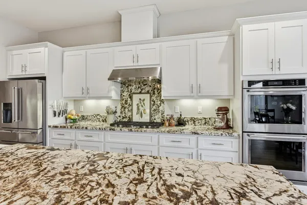 a kitchen with granite countertop a stove sink and cabinets