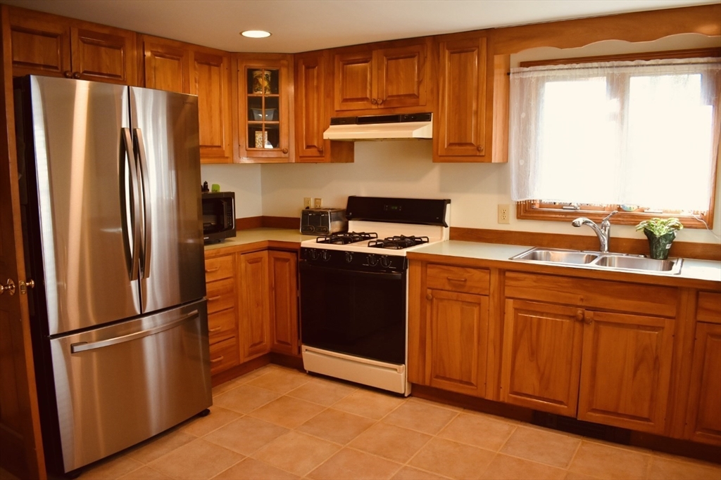 1 Warren Avenue Salisbury, MA 01952 - Photo 10 of 29 a kitchen with stainless steel appliances granite countertop a refrigerator sink and cabinets