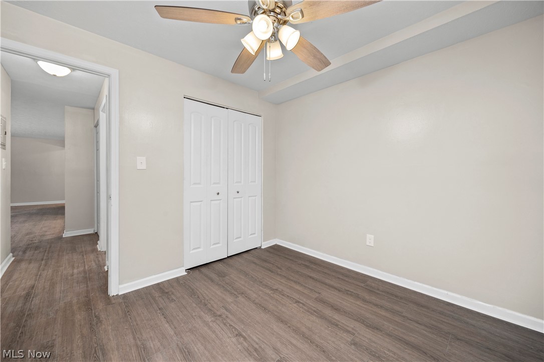 5382 Lee Road, Unit 102 Maple Heights, OH 44137 - Photo 23 of 25 Unfurnished bedroom with dark wood-style flooring, a closet, and a ceiling fan