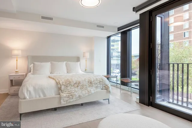 a bedroom with a bed and large windows