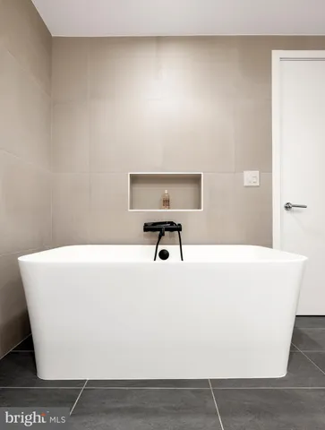 a bedroom with a bed and large mirror with window