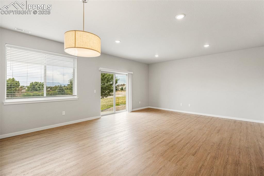 5466 Arden Grove Colorado Springs, CO 80922 - Photo 11 of 35 an empty room with wooden floor and windows
