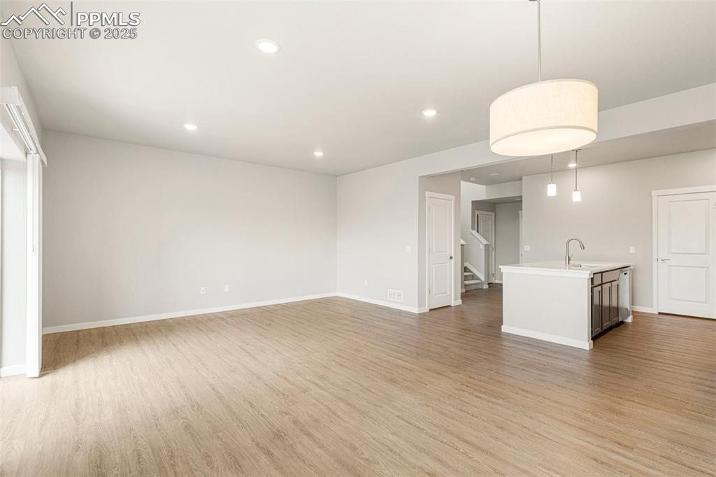 5466 Arden Grove Colorado Springs, CO 80922 - Photo 12 of 35 a view of an empty room with wooden floor and a window