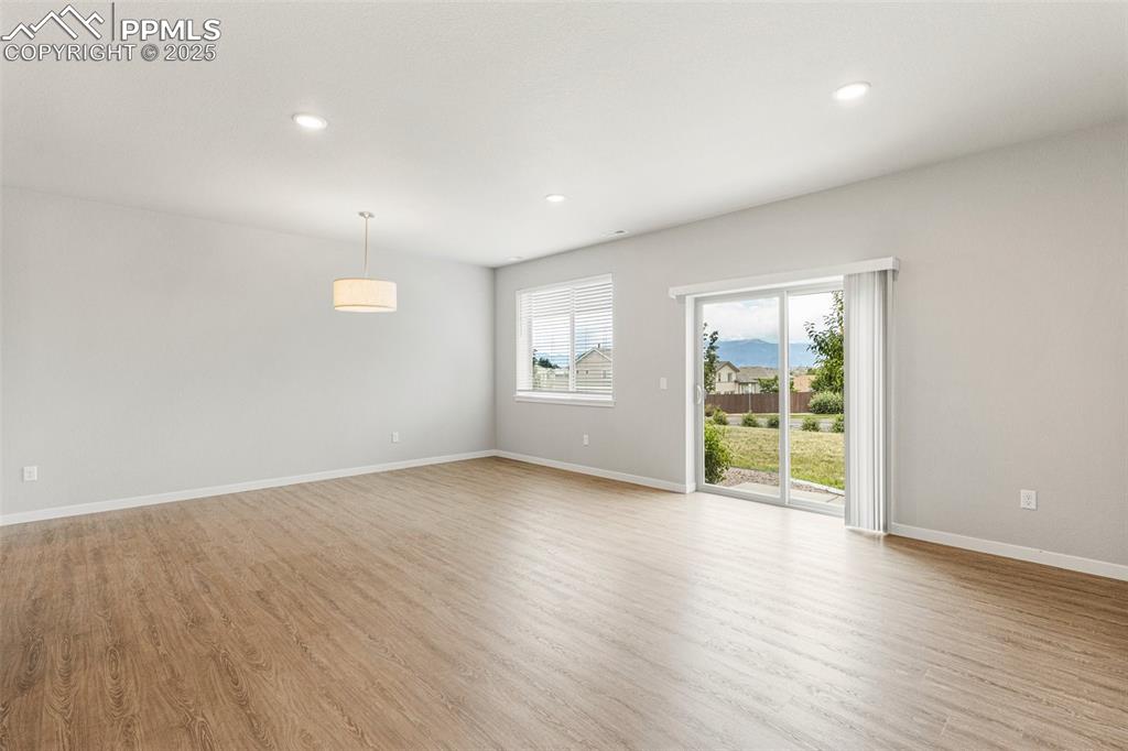 5466 Arden Grove Colorado Springs, CO 80922 - Photo 13 of 35 an empty room with wooden floor and windows