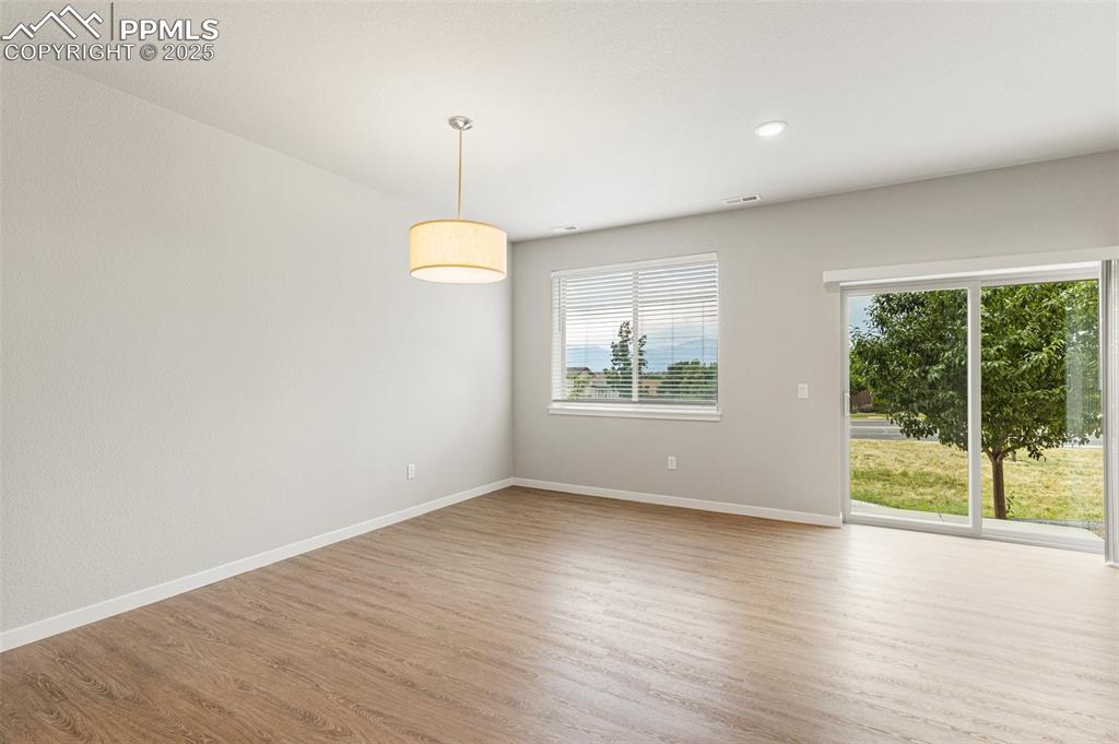 5466 Arden Grove Colorado Springs, CO 80922 - Photo 14 of 35 a view of an empty room with wooden floor and a window