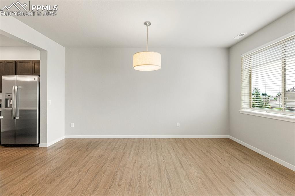 5466 Arden Grove Colorado Springs, CO 80922 - Photo 15 of 35 an empty room with wooden floor and windows