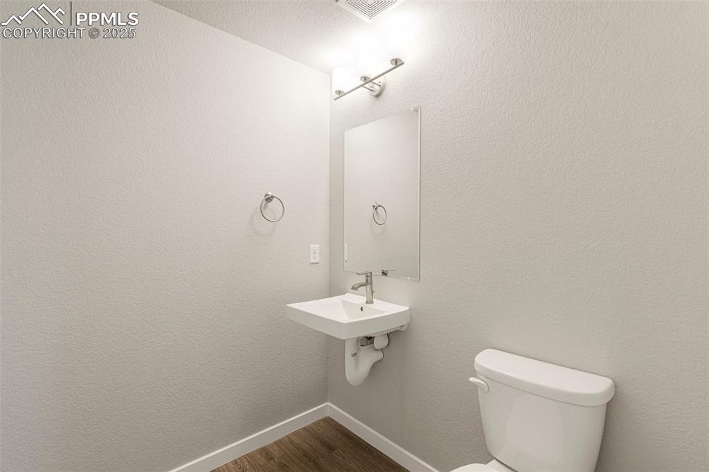 5466 Arden Grove Colorado Springs, CO 80922 - Photo 17 of 35 a bathroom with a sink a toilet and a mirror