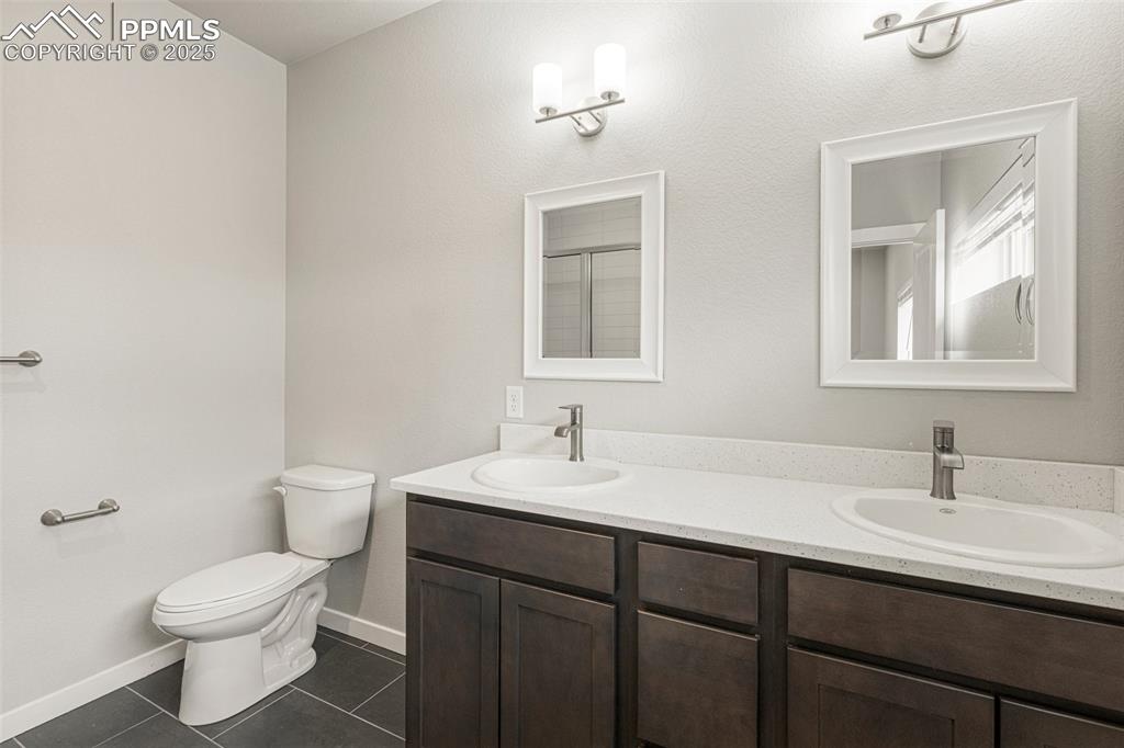 5466 Arden Grove Colorado Springs, CO 80922 - Photo 24 of 35 a bathroom with a sink toilet and mirror