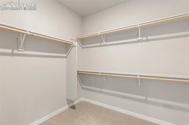 a view of walk in closet with empty racks