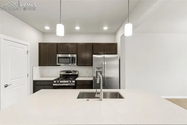 a kitchen with stainless steel appliances a refrigerator a stove a sink and a oven
