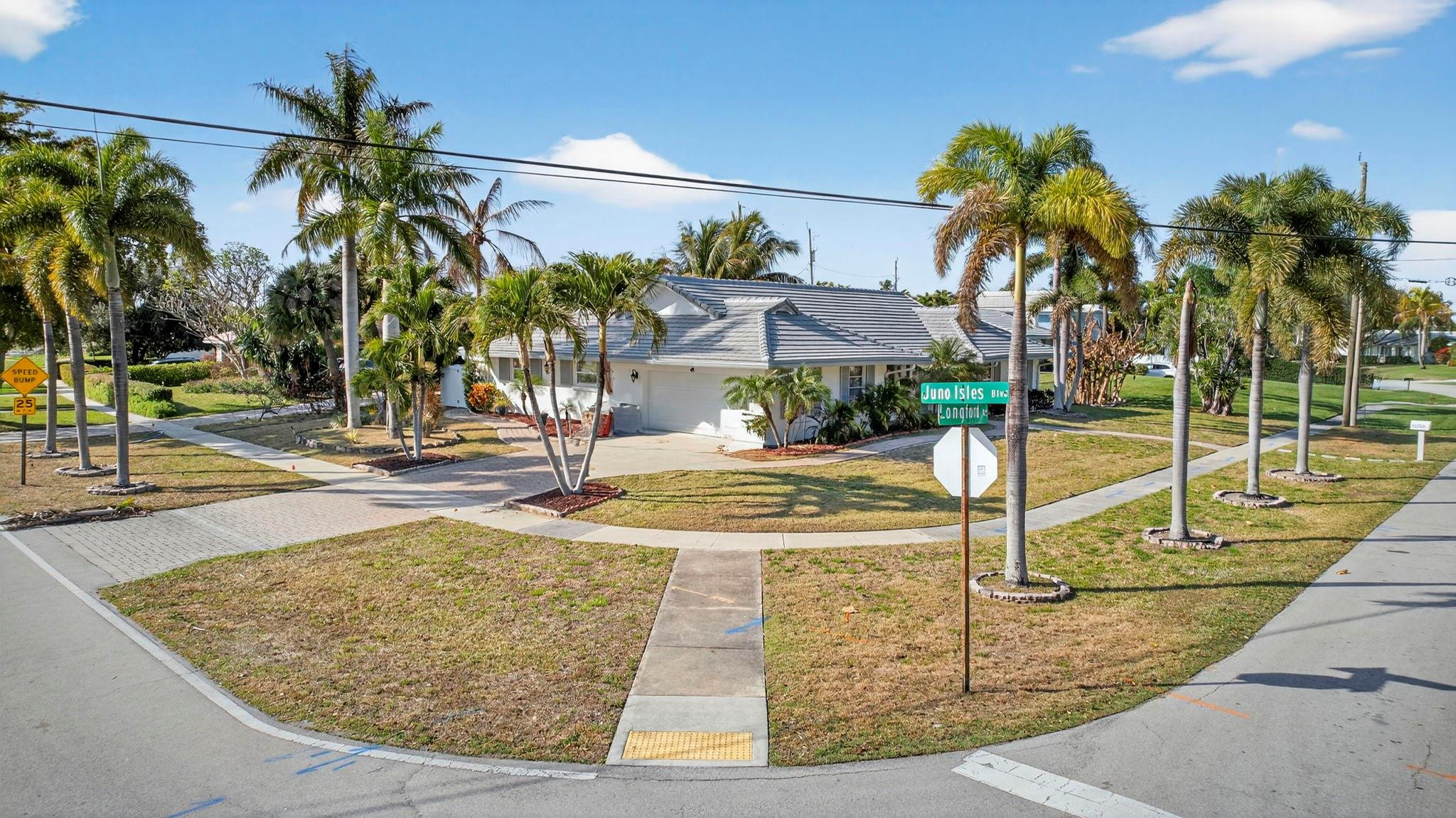 12753 Longford Road North Palm Beach, FL 33408 - Photo 12 of 68 a view of a swimming pool with a lawn chairs and palm tree