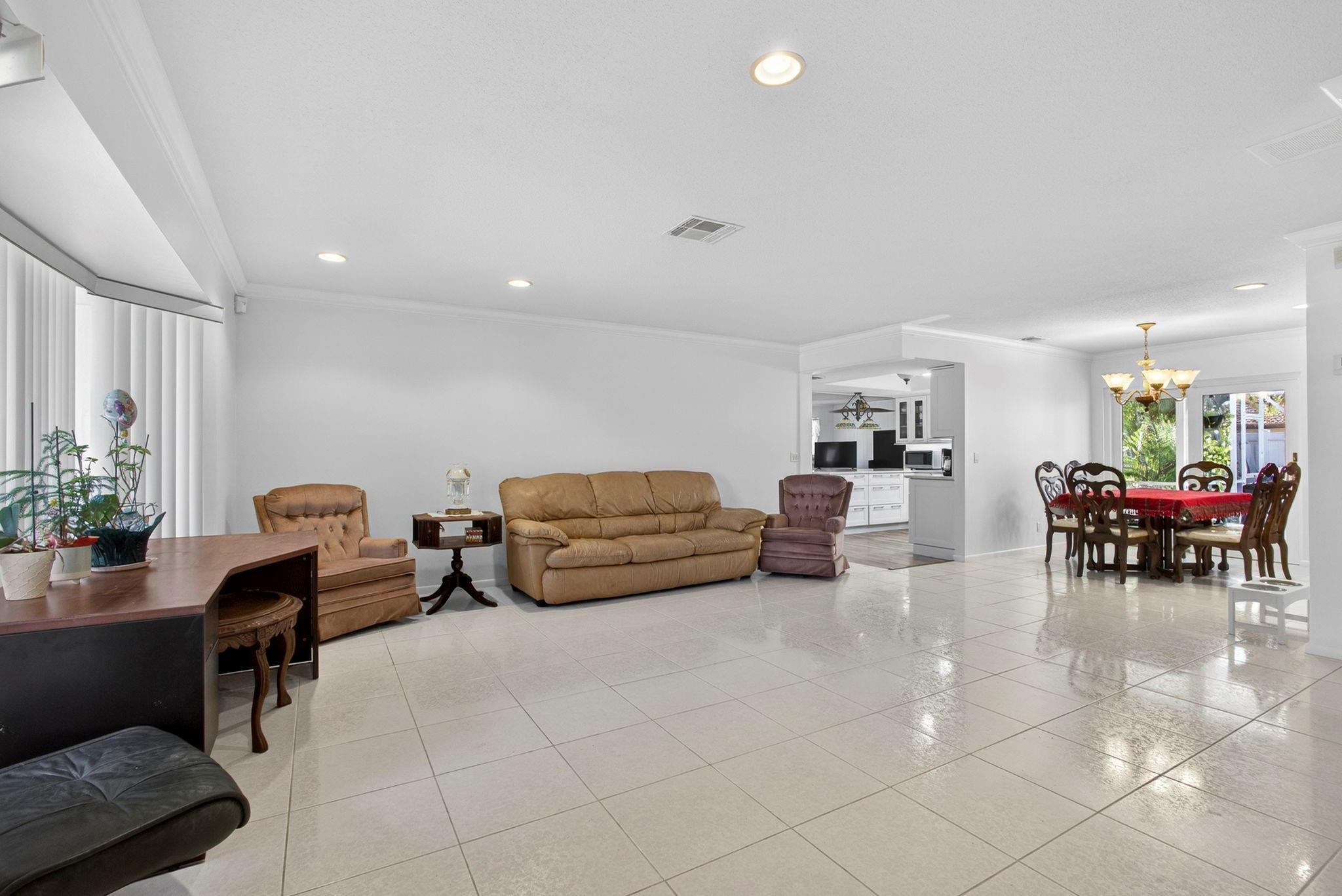 12753 Longford Road North Palm Beach, FL 33408 - Photo 16 of 68 a living room with furniture and a dining table with potted plants