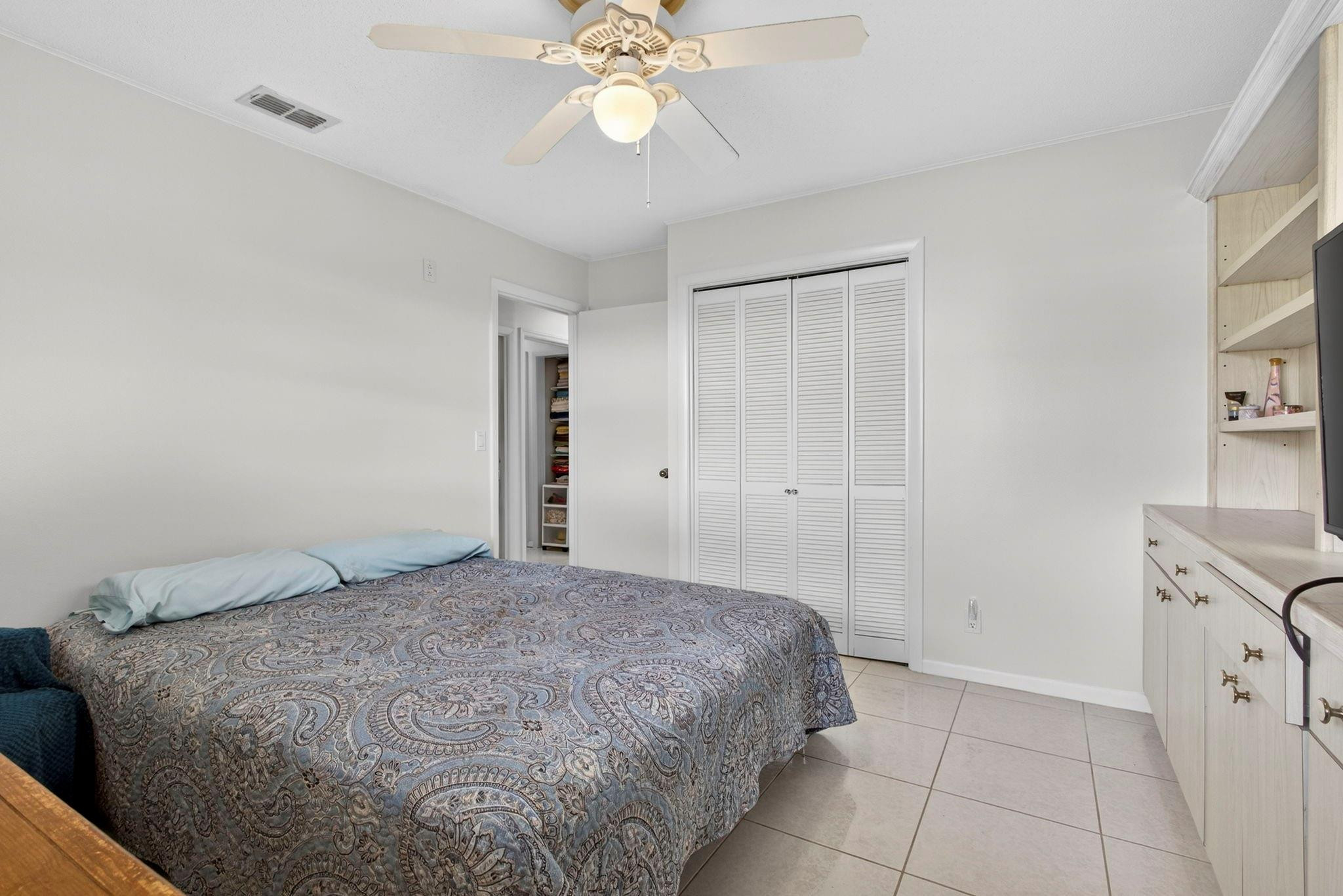 12753 Longford Road North Palm Beach, FL 33408 - Photo 42 of 68 a bedroom with a bed and a chandelier