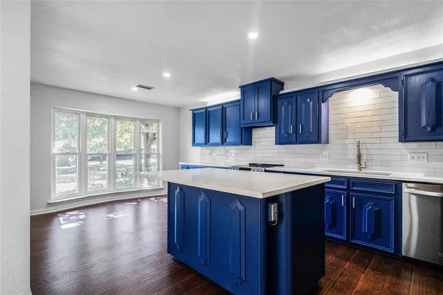 a kitchen with a sink window and cabinets