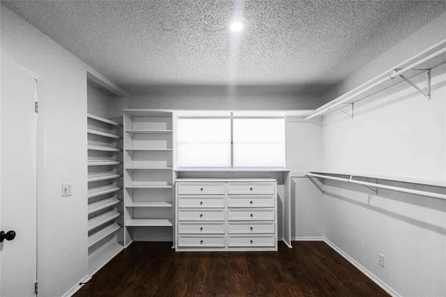 a view of walk in closet with empty racks