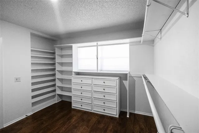 a view of walk in closet with empty racks