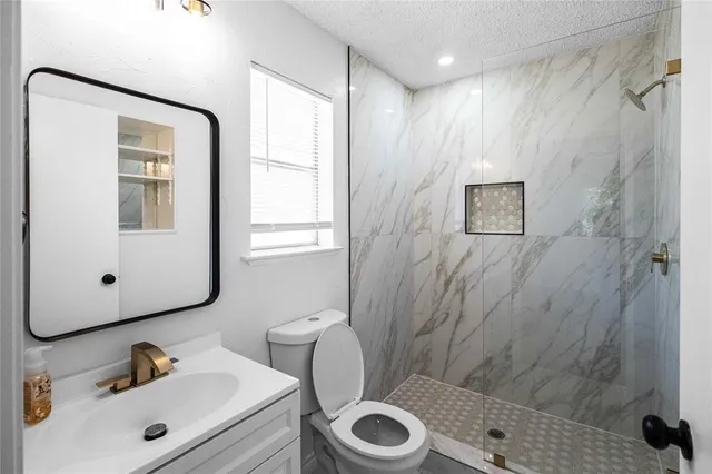 a bathroom with a sink a toilet and shower